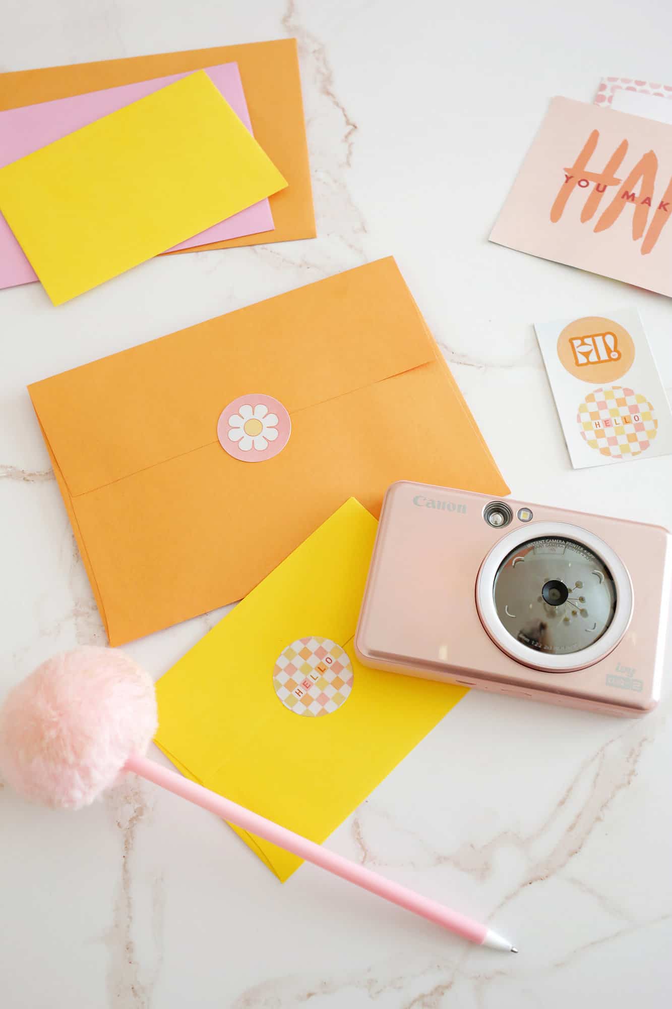 custom mail stickers added to colorful envelopes next to an instant camera