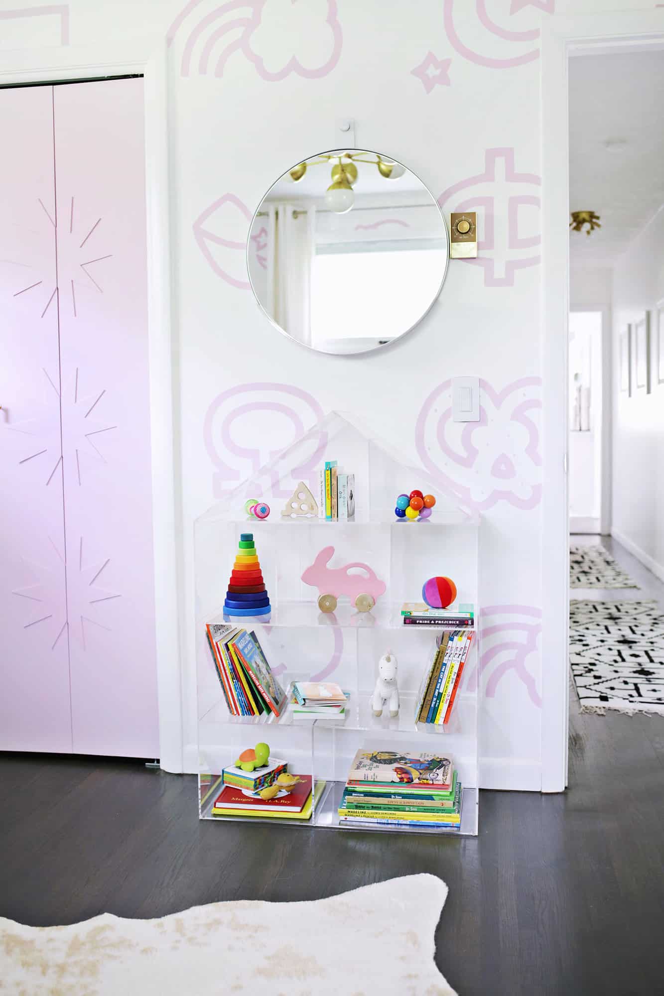 house shaped bookshelf with kid's books and toys on it