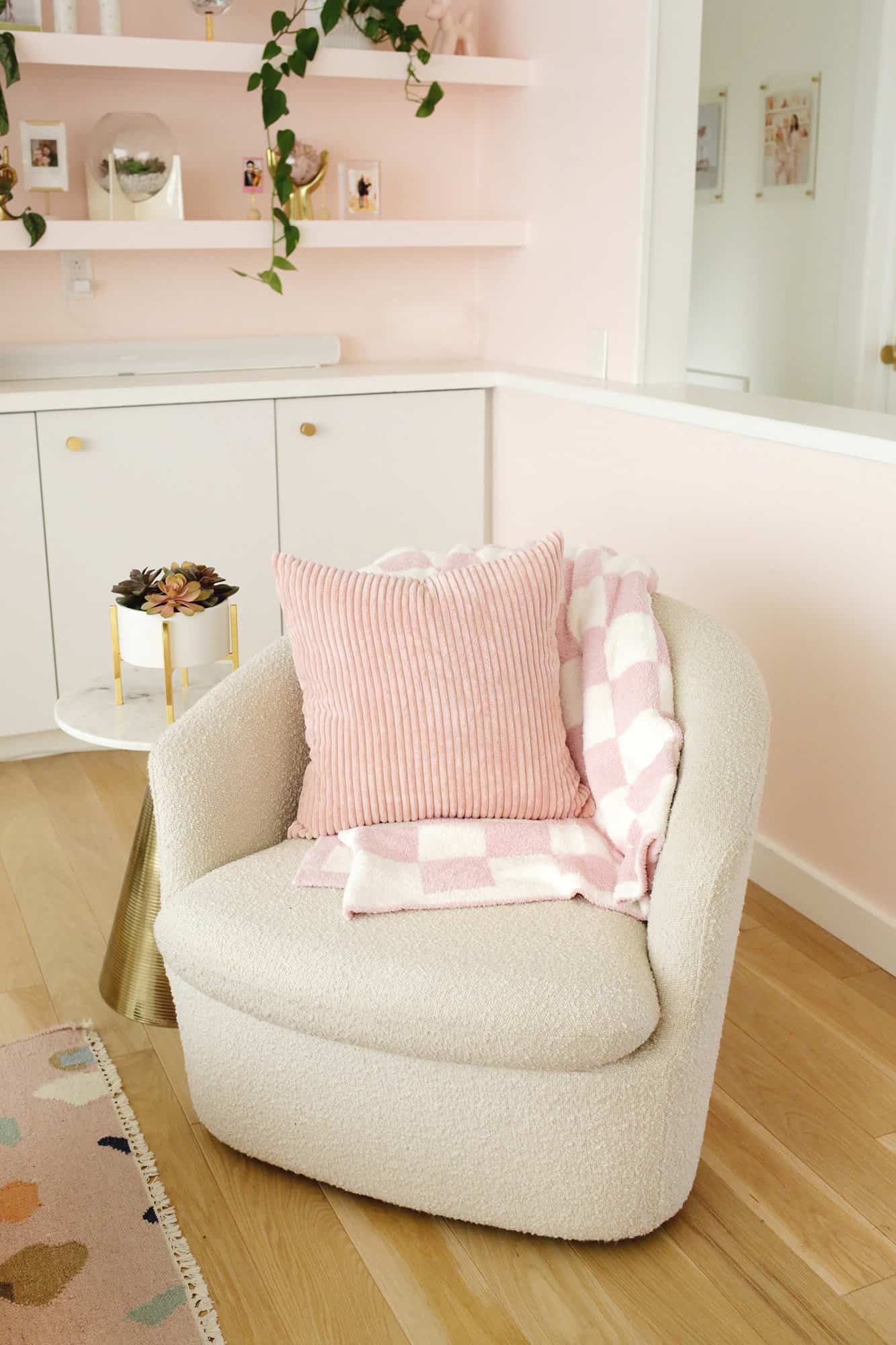 분홍색과 흰색 담요와 분홍색 베개가 있는 의자
