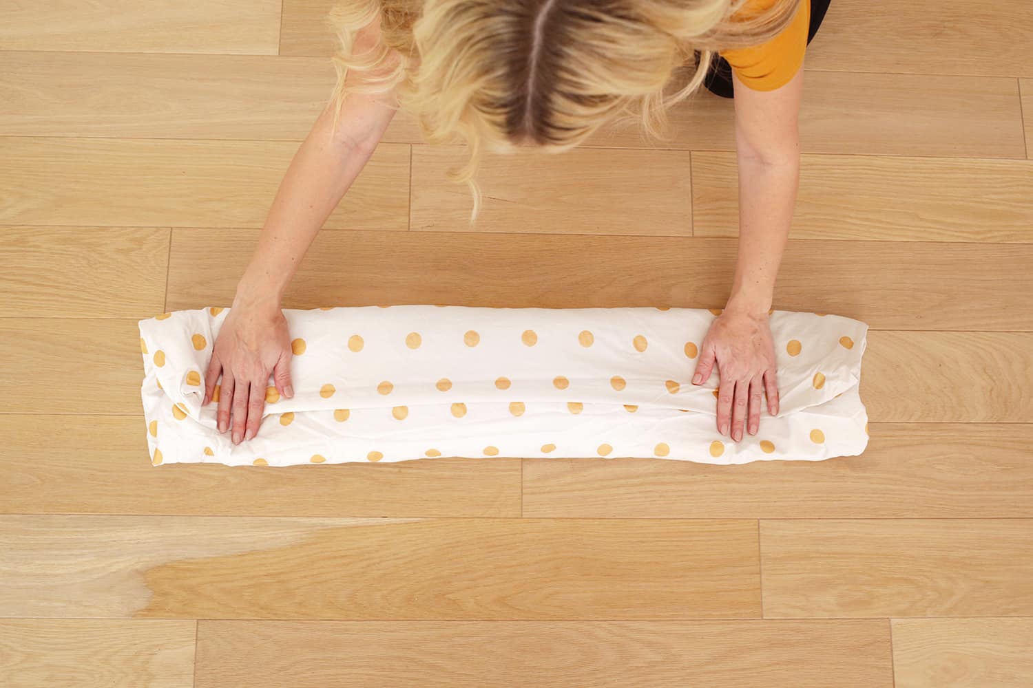 demostrando cómo doblar una sábana ajustable