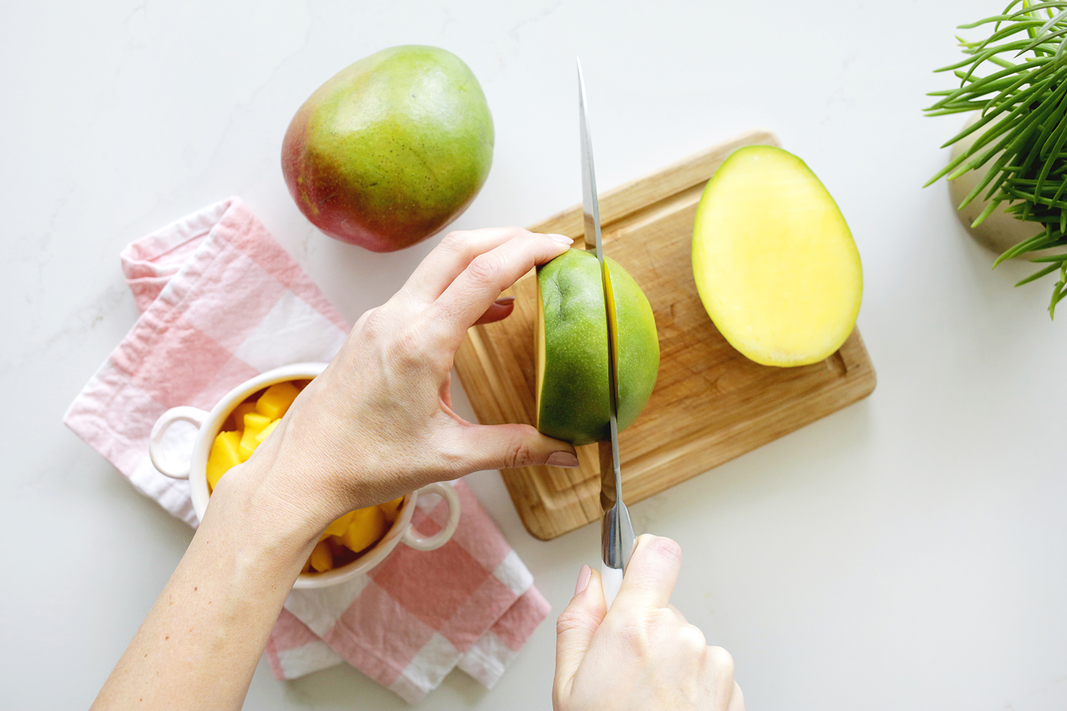 Cutting into mango on cutting board