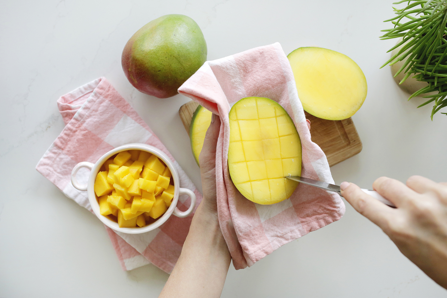 Hand cutting into half a mango