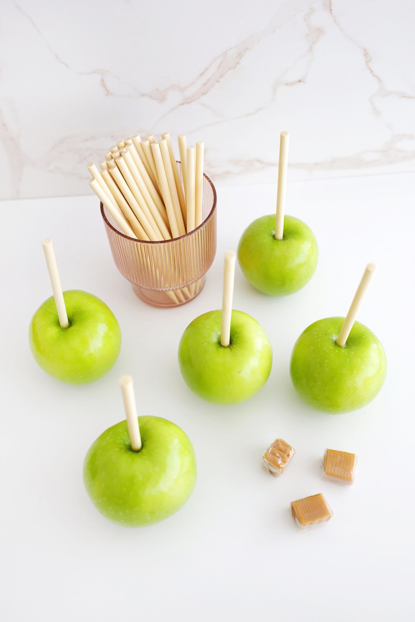 skewers added into apples for caramel apples