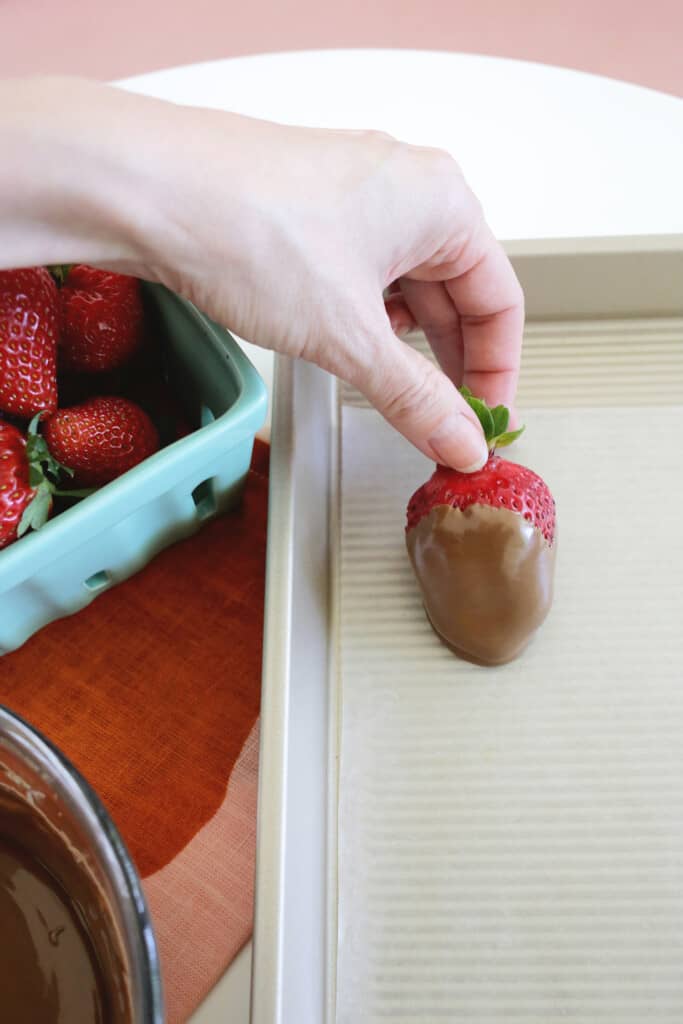 setting chocolate covered strawberry on wax paper