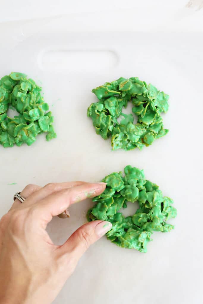 shaping cookie batter into wreaths for christmas wreath cookies