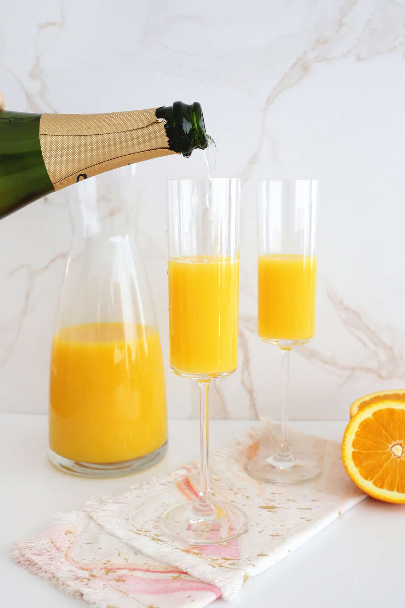 pouring champagne into mimosa
