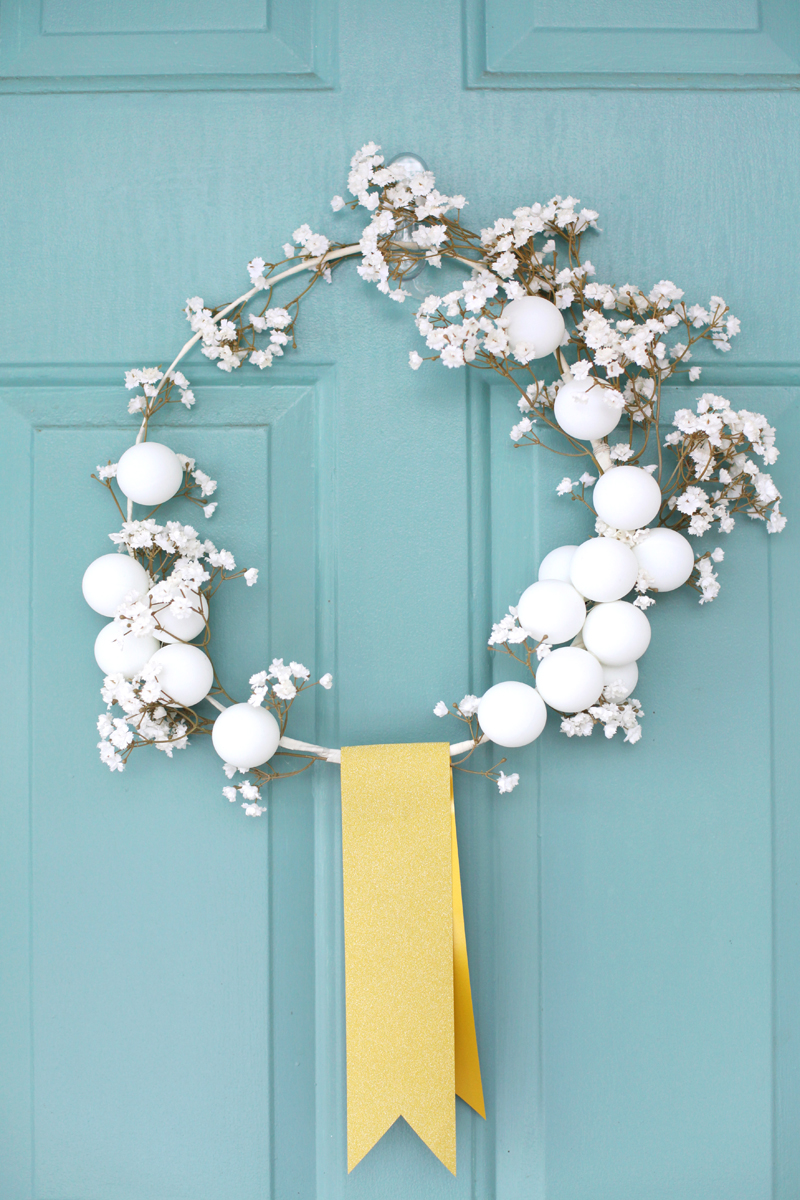 Make this delicate white winter wreath with a coat hanger and ping pong balls!