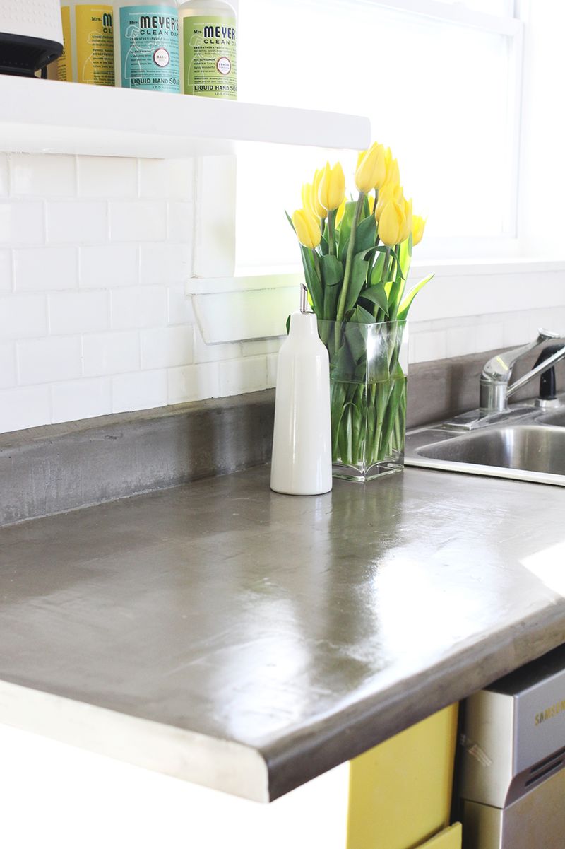 close up of finished concrete countertop with a vase of yellow flowers on top