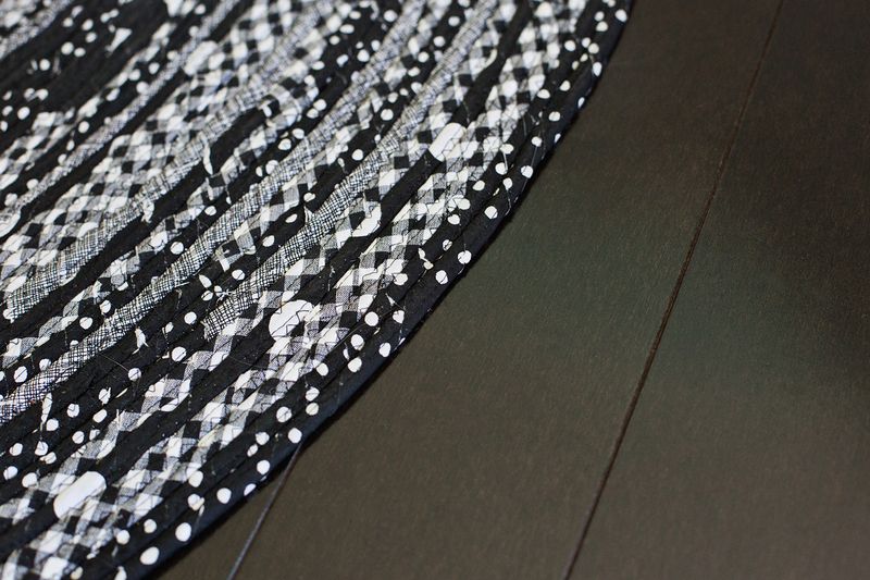 a close up of the edge of the black and gray circle rope rug