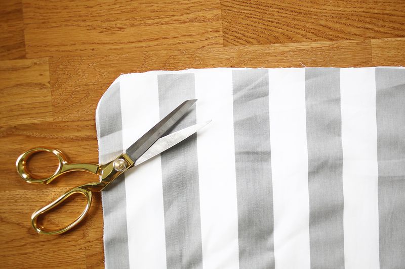 white and gray stripped fabric with gold scissors on top