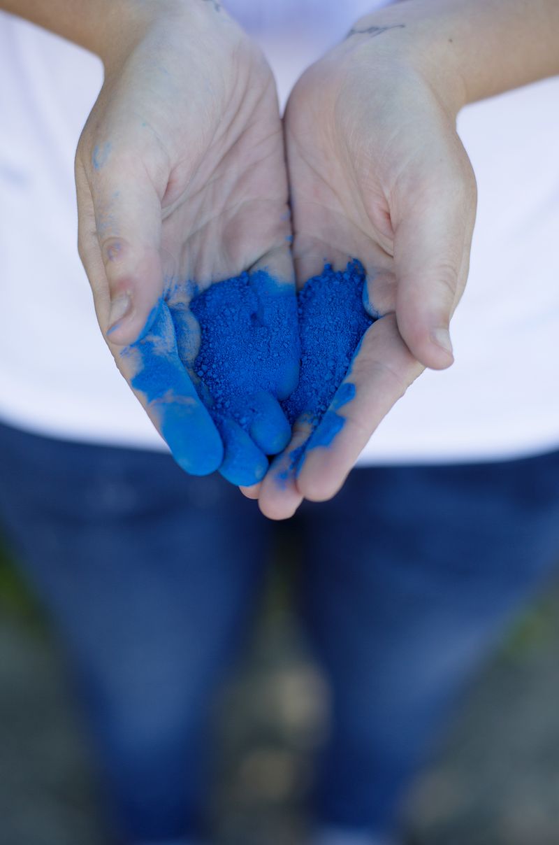 someone holding blue powder in their hands