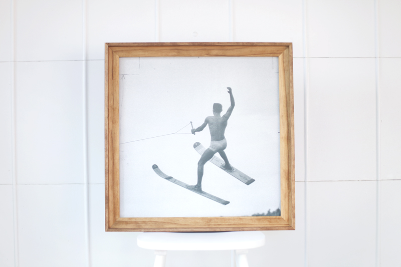 a wood frame around a picture of a man on water skis