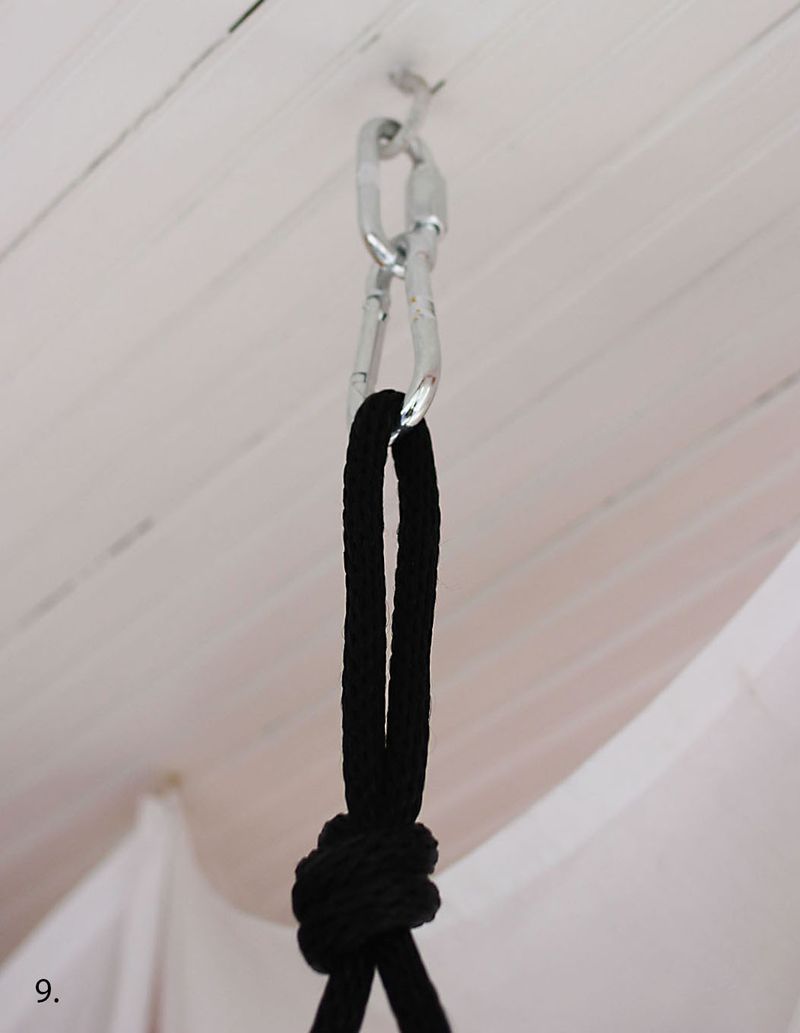 2 clips hanging from ceiling with black rope looped through them