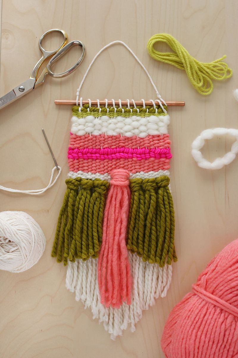 weaving project with different colored yarn with scissors and yard around it