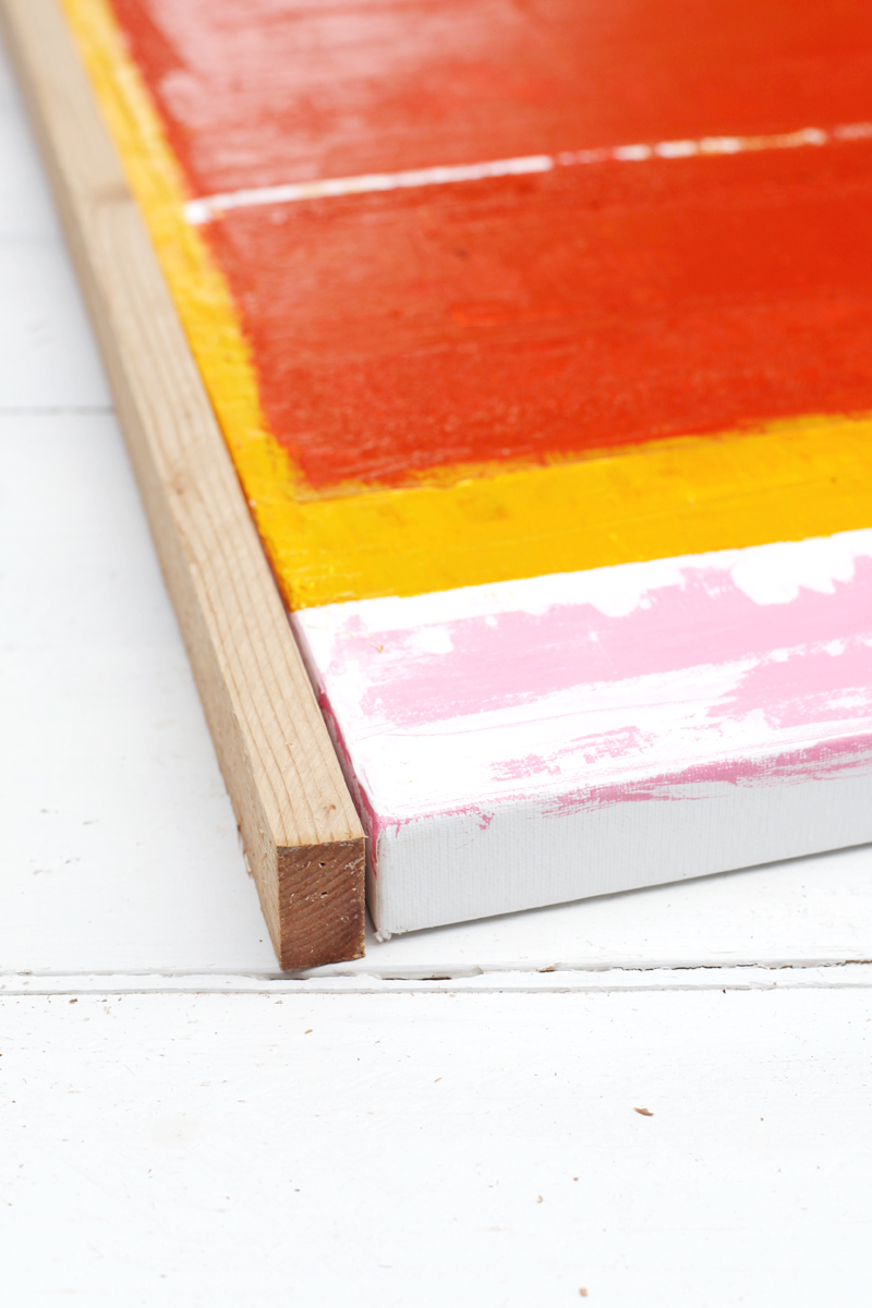 yellow, orange and pink painted canvas lined up against an unpainted board