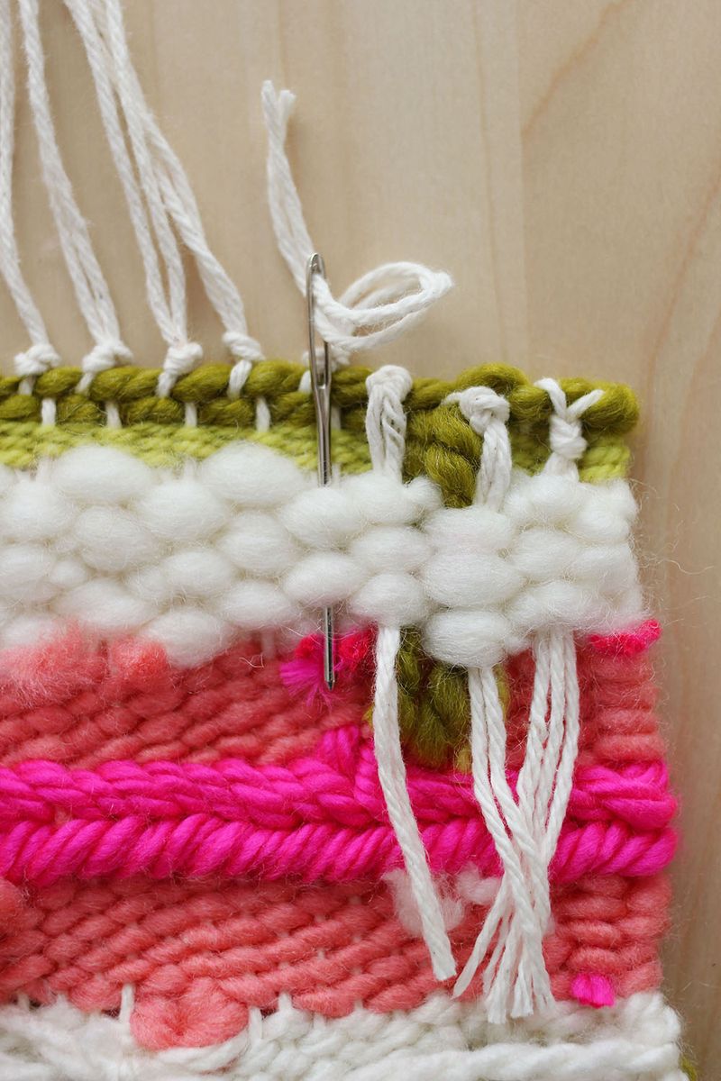 white yarn being three through weave with needle