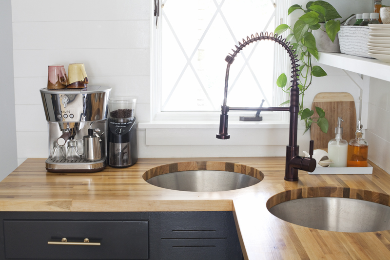 kitchen sink with butcher block countertops and an espresso machine on it