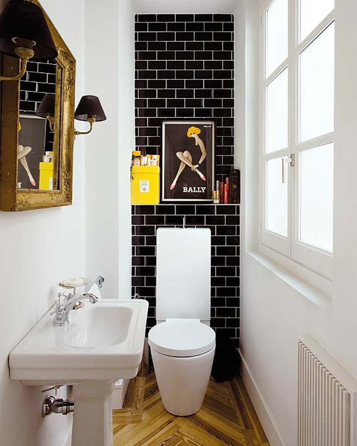 black Subway tile on a bathroom wall behind a white toilet