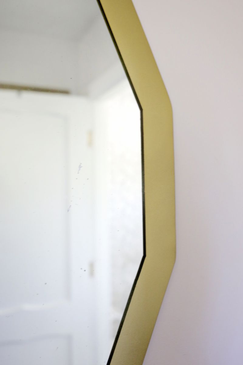a close up of the gold trim on the circle mirror