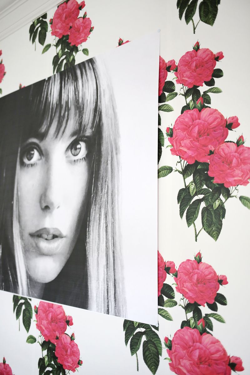 a photo of a woman tacked to the white and pink flower wallpaper