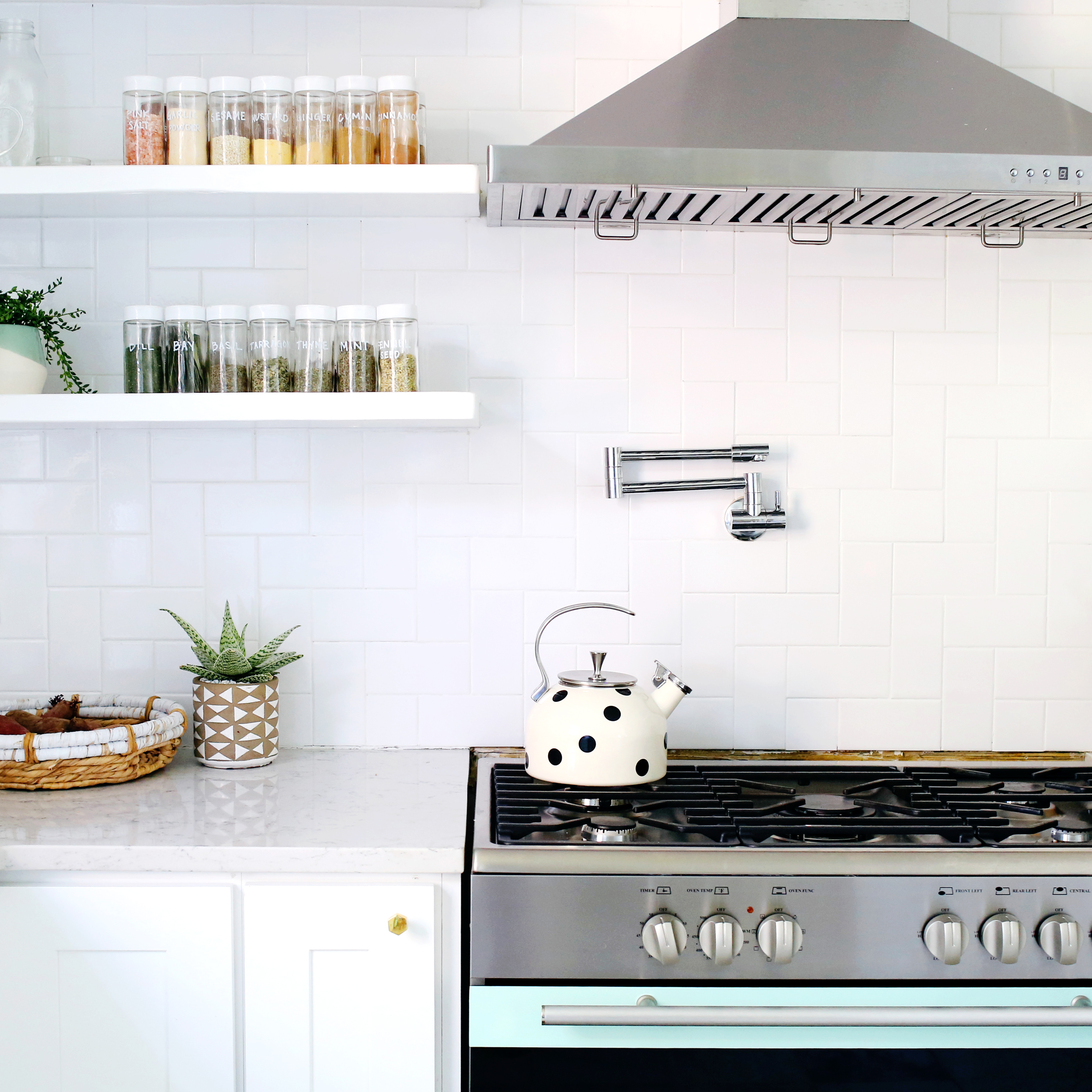 white kitchen with white cabinets and white countertop with teal stove