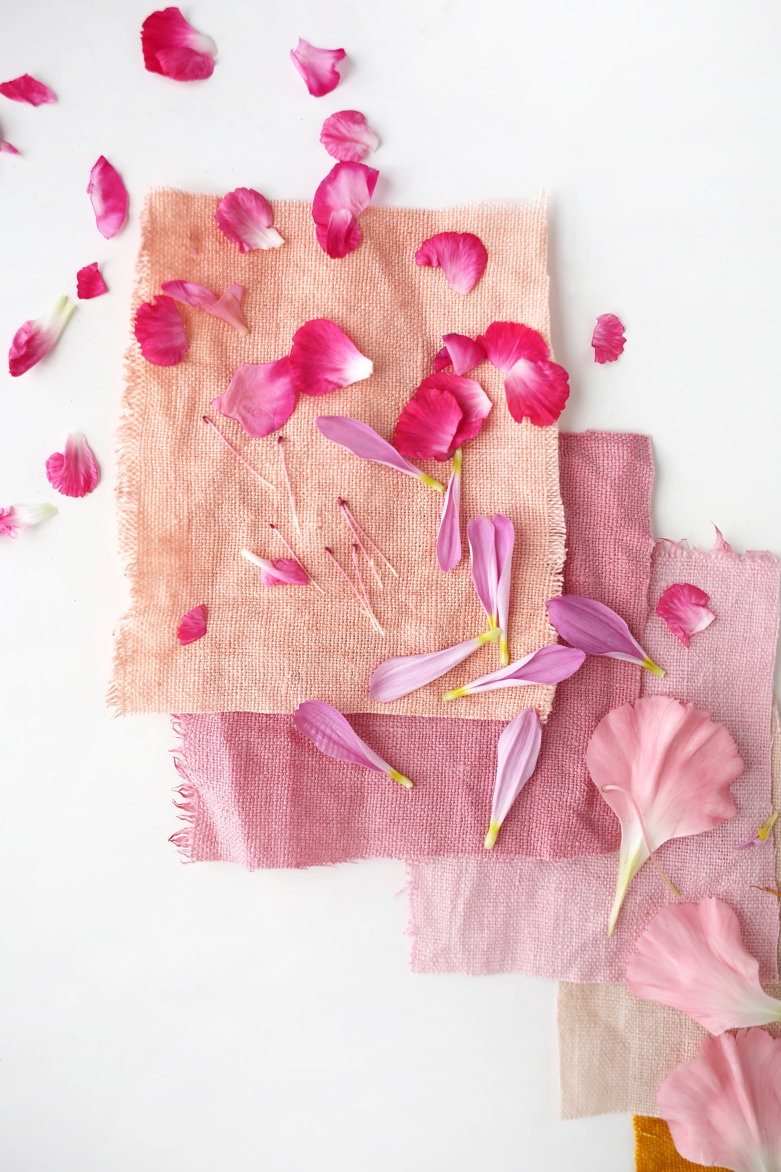 3 pink square pieces of canvas bags with flower petals on them