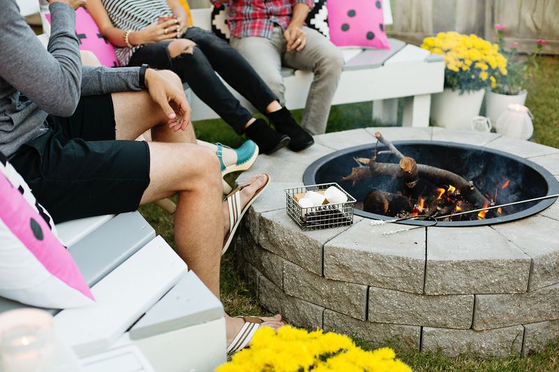 2 couples sitting around fire pit with their feet propped on fire pit