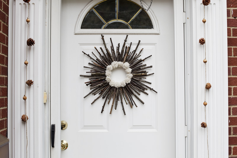 twig pom pom wreath on a white door