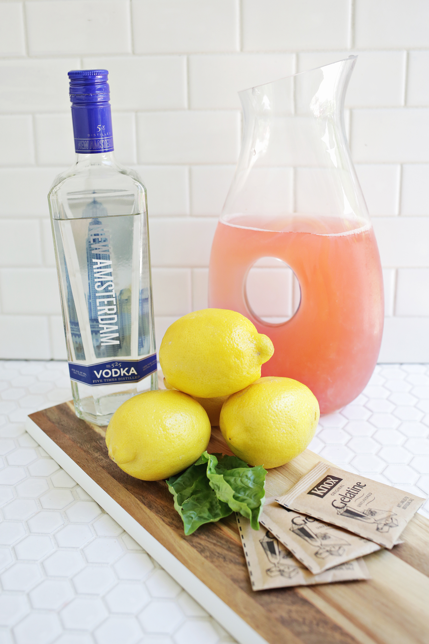 bottle of vodka, a pitcher of pink lemonade, 3 lemons and 3 packets of gelatine