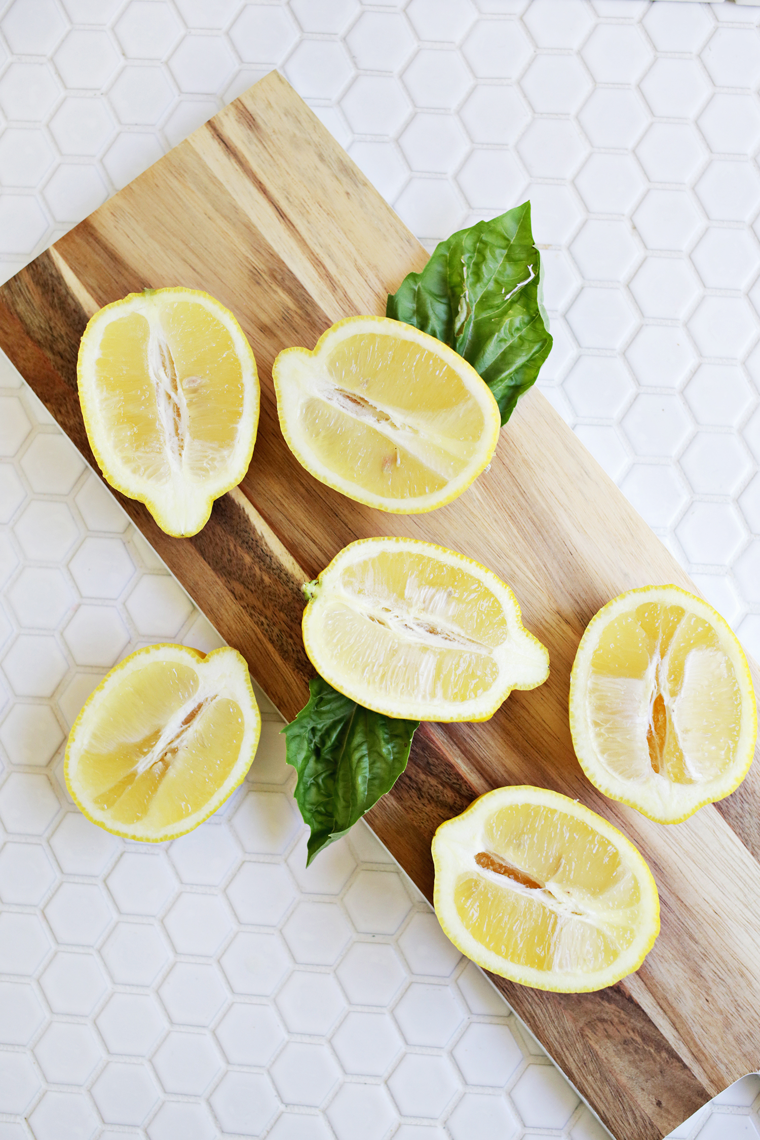 6 lemon halves on a wooden cutting board