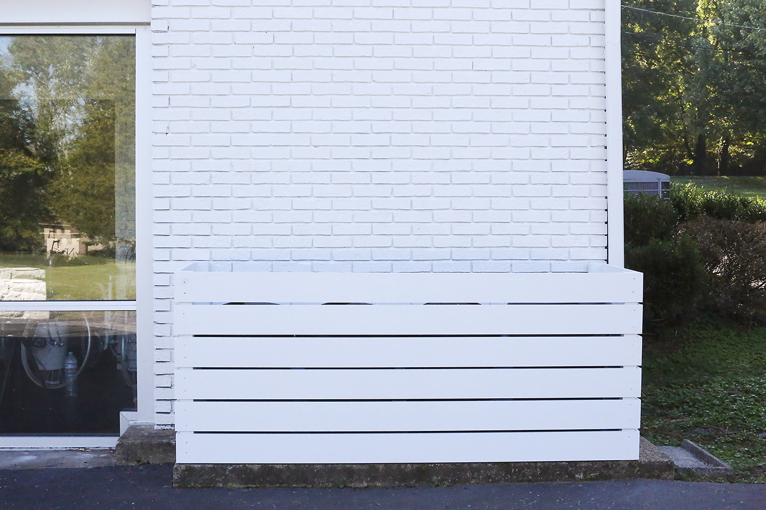 white plank fence around trash cans