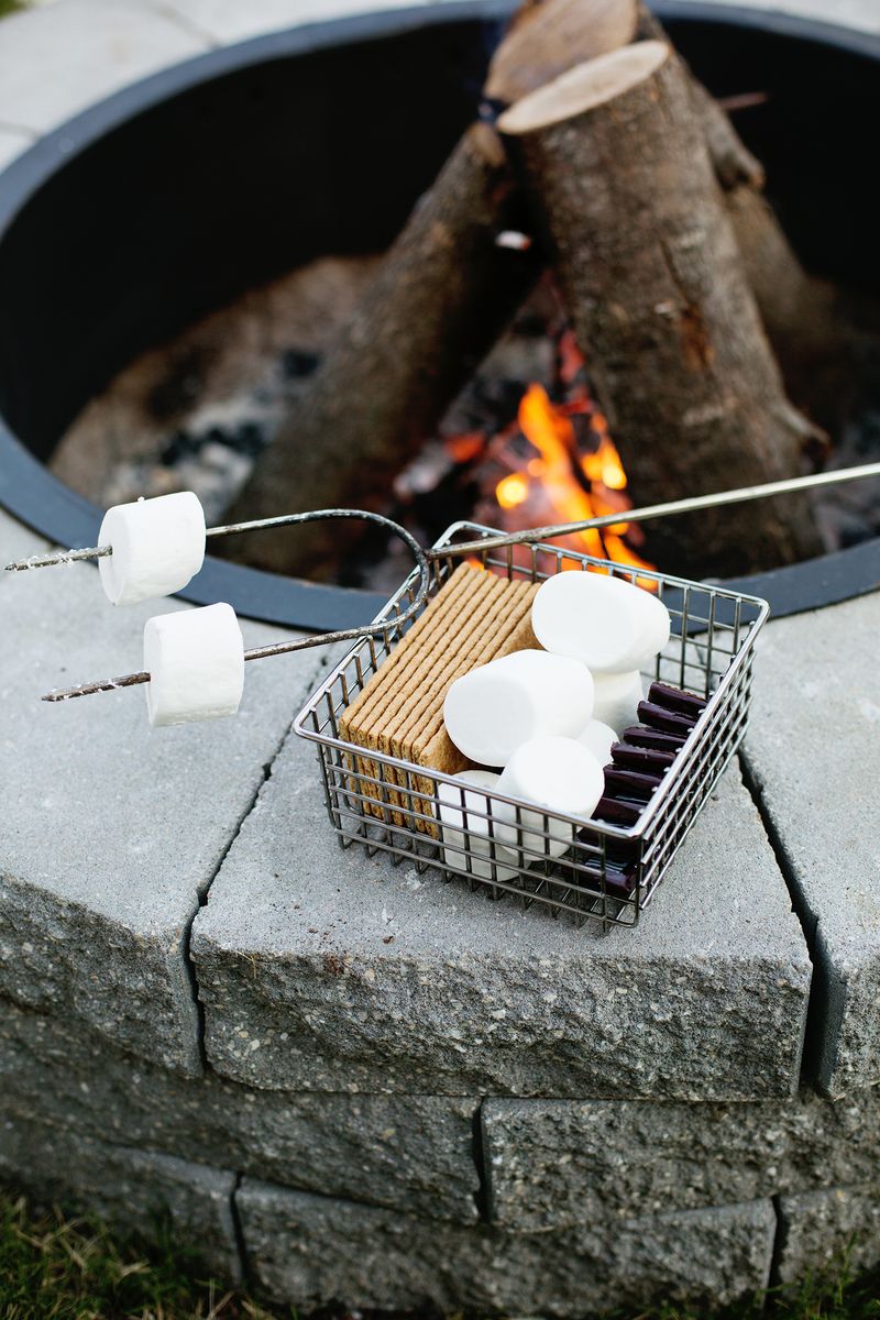 basket of more supplies and skewer on tip of fire pit with fire buring