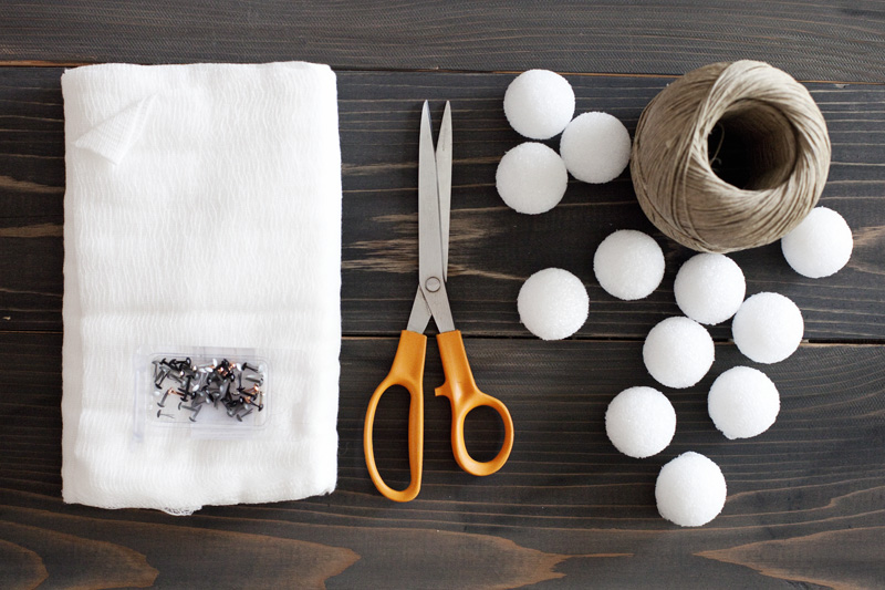 styrofoam balls, cheesecloth, scissors, black and white brads, and a roll of string