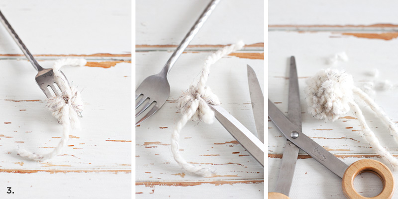 fork with white yarn tied around it, scissors with white yarn wrapped around it, and tied white yarn by scissors