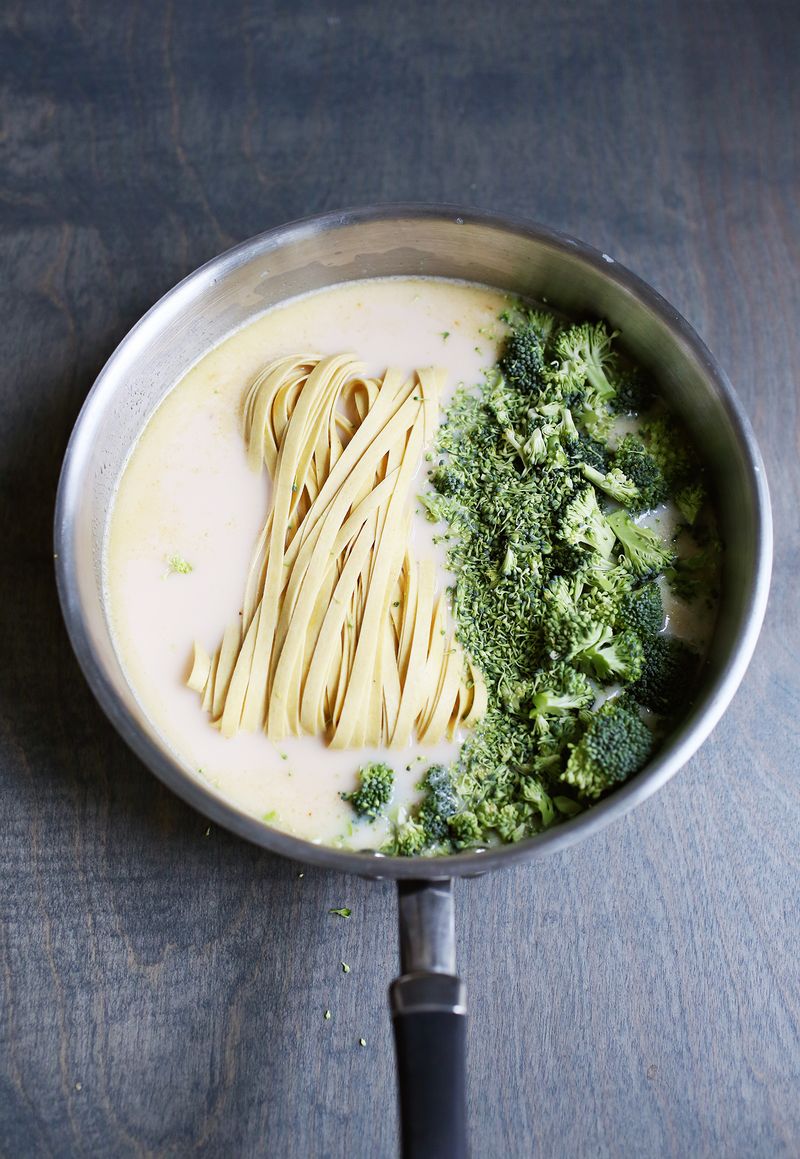 a pot of ingredients for creamy broccoli pasta